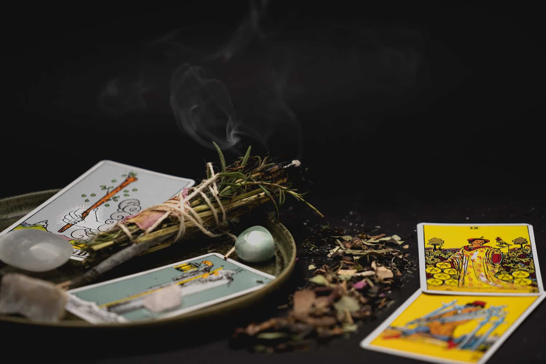 tarot cards near burning plants in close up photography
